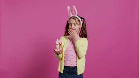 lovely little girl with bunny ears sending air kisses in studio