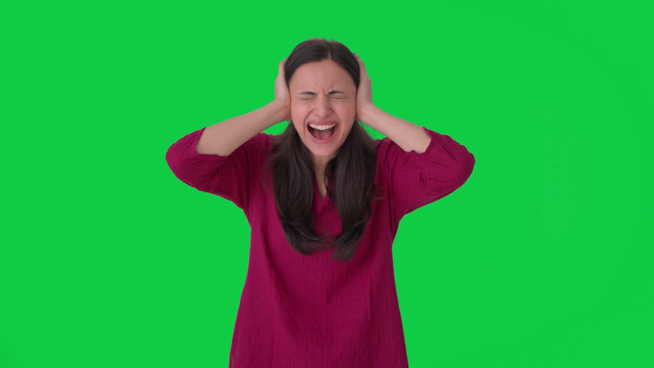 좌절 된 인도 여성 은 귀 를 닫고 소리 치고 녹색 스크린 을 들었다