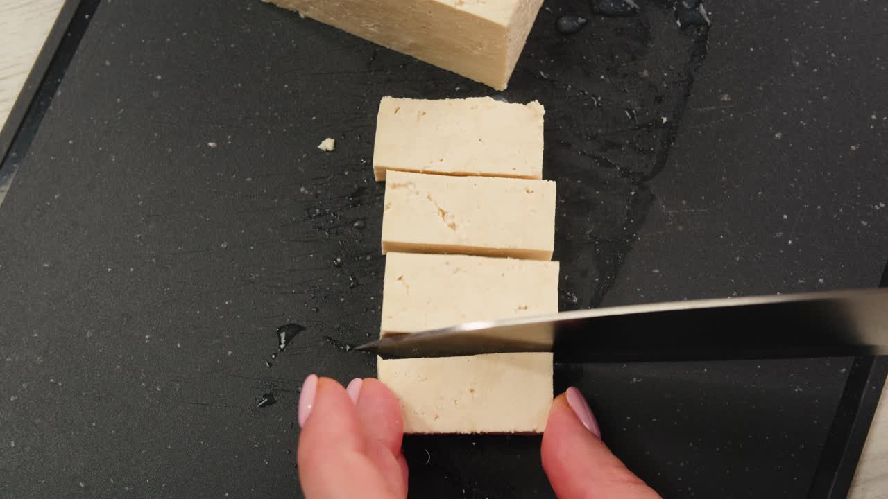 Slicing tofu on a cutting board