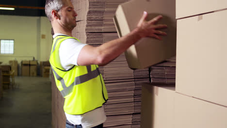 trabajador de almacén apilando cajas de cartón