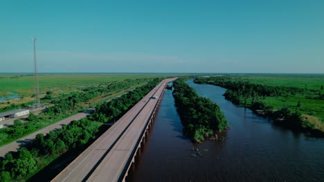 semi-trucks hauling freight across the manchac swamp bridge on i-55, illustrating logistics over a louisiana wetland causeway.