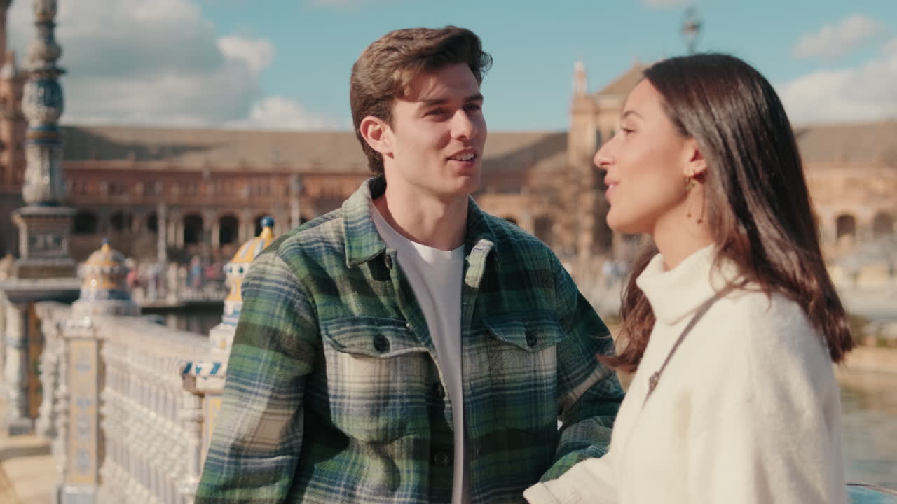 Happy couple man and woman talking standing on bridge in old European city