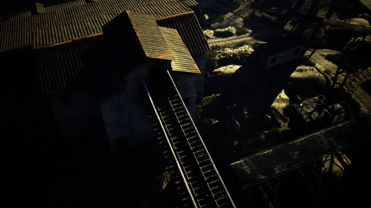 Forgotten railway tracks lead to an abandoned building in fading light