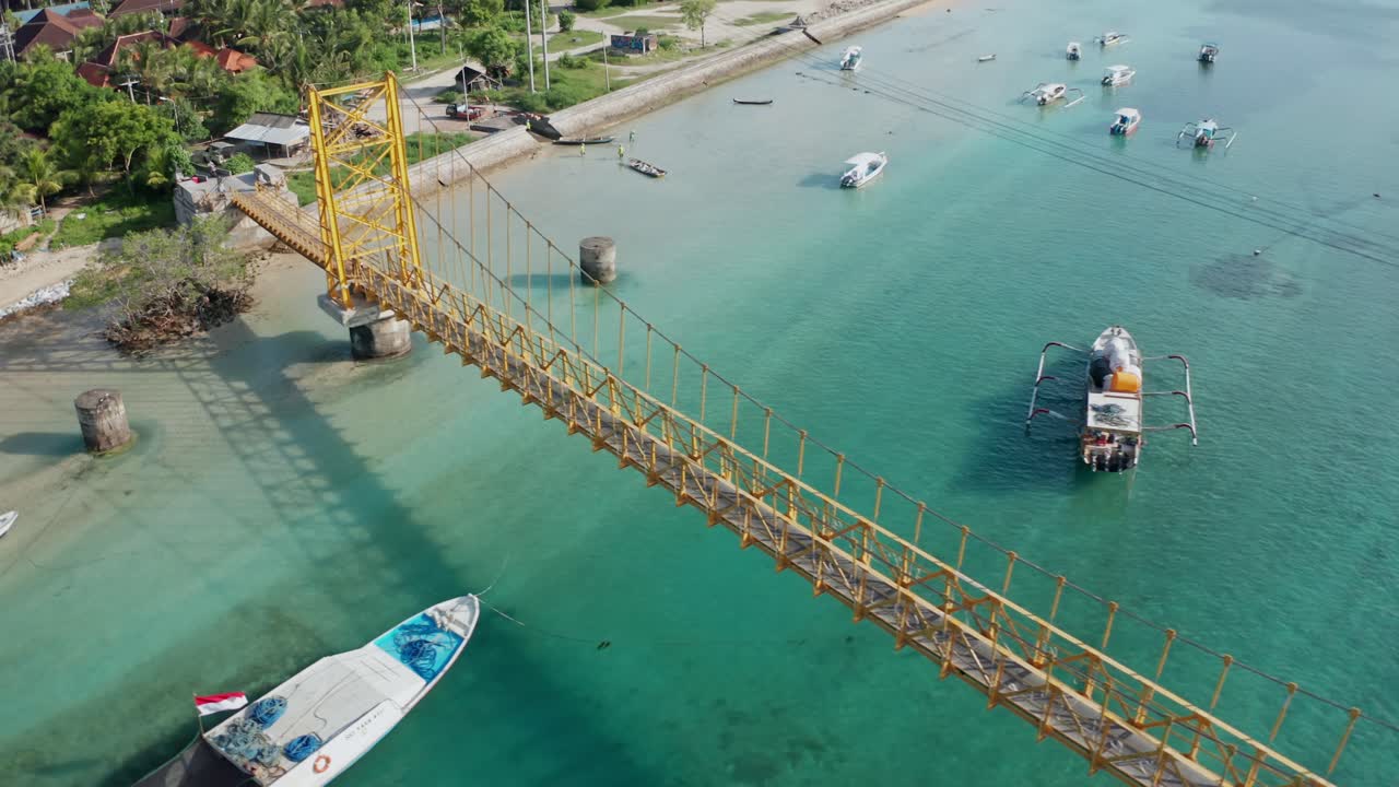 A bright, high-angle aerial drone shot capturing the famous Yellow Bridge (Jembatan Kuning) which connects the islands of Nusa Lembongan and Nusa Ceningan