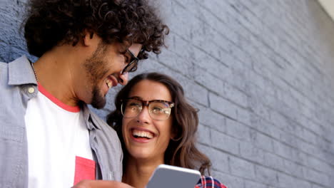 Friends-smiling-while-looking-at-smartphone