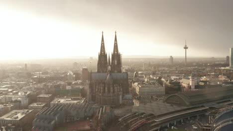 Luftaufnahme-Des-Gotischen-Kölner-Doms-Gegen-Hellen-Himmel-Bei-Leichtem-Regen.-Kippen-Sie-Nach-Unten,-Wenn-Züge-Ankommen-Oder-Den-Bahnhof-Verlassen.-Köln,-Deutschland