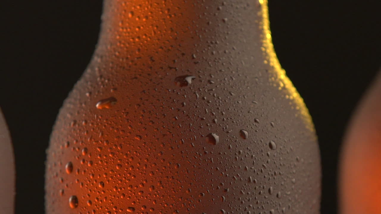 Three beer bottle rotating on black background
