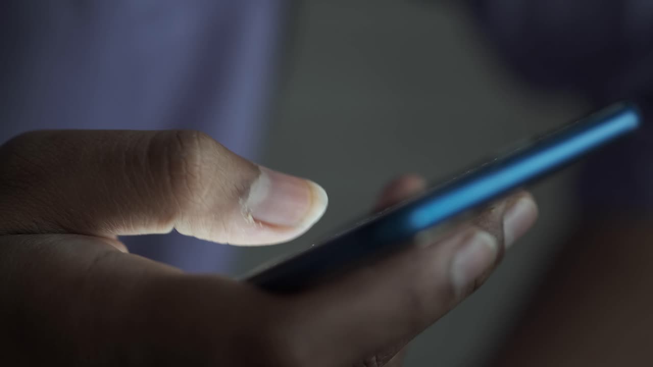 persona que utiliza un teléfono inteligente por la noche