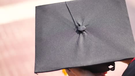 student hold hats in hand during commencement success