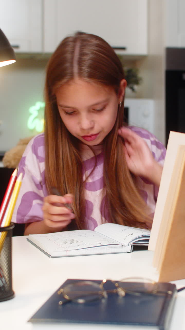 Teenager girl serious homework solves tasks from book writes notes in notebook deep focus study math