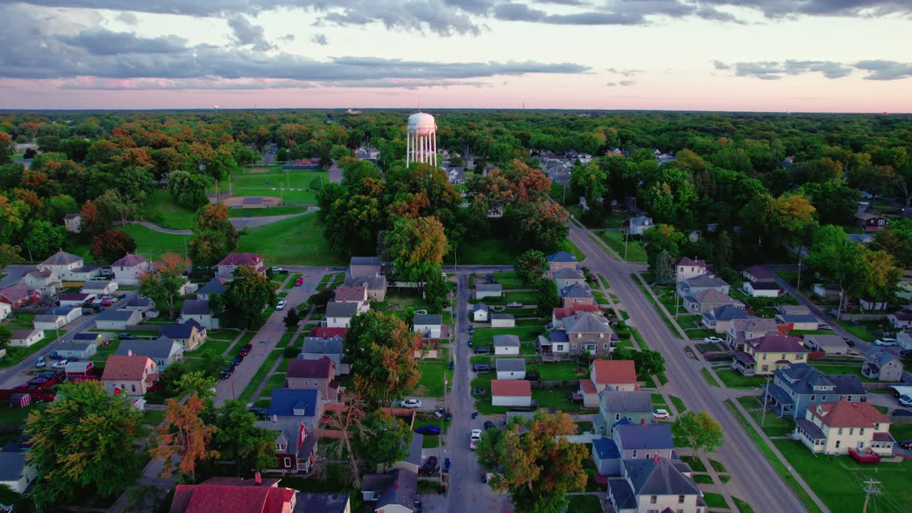 Aerial View of a Suburban Town at Sunset with a Water Tower