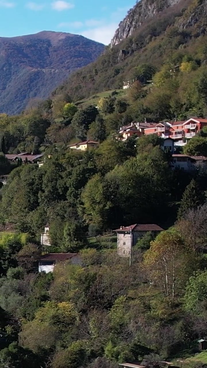Vista aérea de uma vila nos Alpes Italianos em meio a uma natureza deslumbrante
