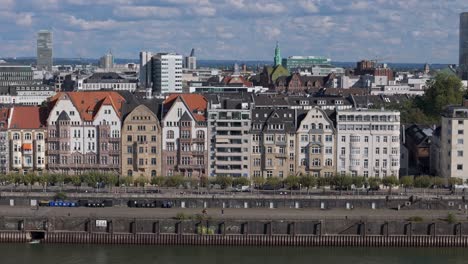 aerial panoramic cityscape of dusseldorf, rhine river waterfront lined by buildings