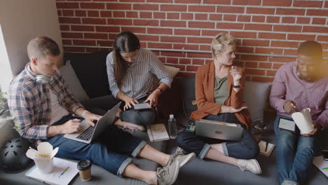 vielfältige geschäftsleute genießen die mittagspause, essen zusammen, genießen die entspannung im büro, brainstormen, diskutieren kreative ideen, freunde arbeiten in einem entspannten café zusammen, treffen sich oben