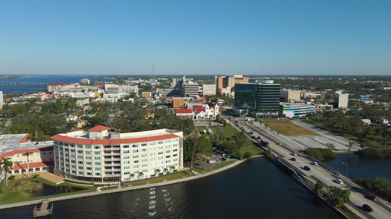 Aerial drone view of downtown Bradenton Florida showcasing buildings, and surrounding cityscape under clear blue skies. Dolly Forward E