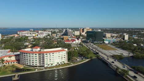 aerial drone view of downtown bradenton florida showcasing buildings, and surrounding cityscape under clear blue skies. dolly forward e