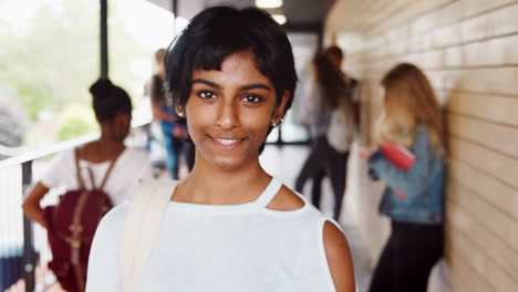 portrait of female student walking into focus outside building