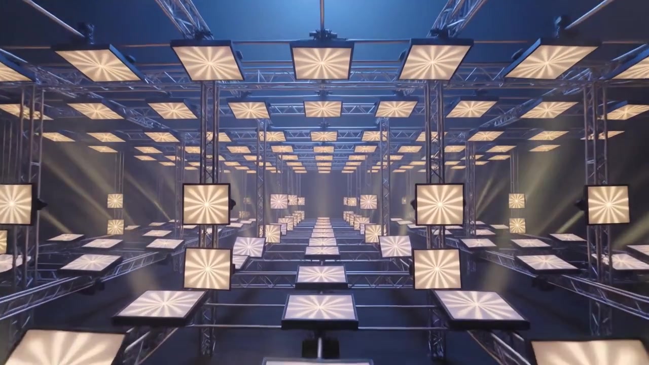 Dolly de cámara comenzando a moverse hacia una estructura de celosía simétrica en un estudio, revelando paneles LED.