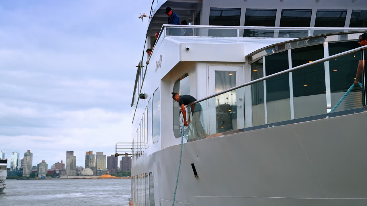 Two men work on board of the cruise boat. Worker throws the life vest to the other boat. New York, USA
