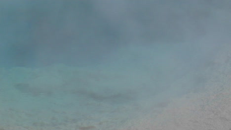 steam rises from a geothermal pool in yellowstone national park 3