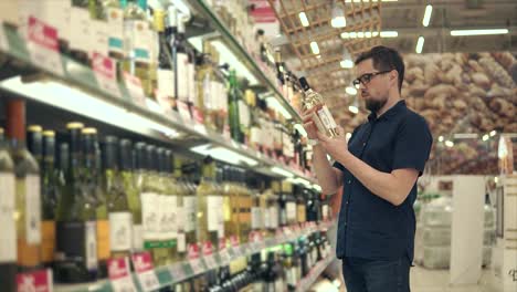 hombre comprando vino en una tienda de comestibles