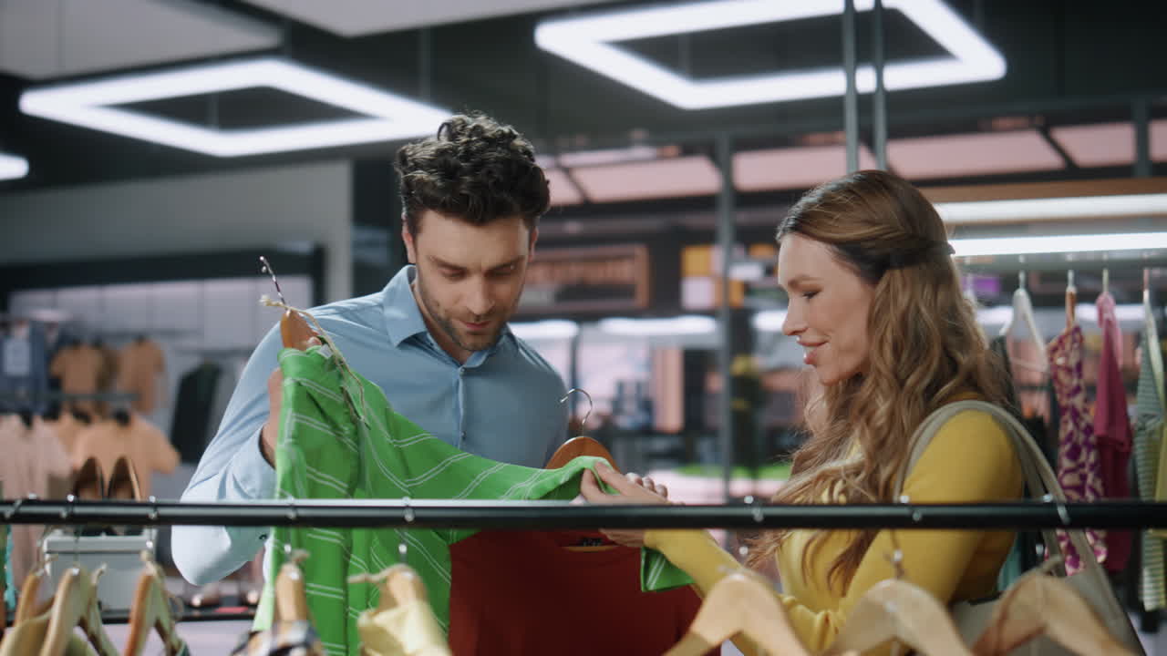 Primo piano di una donna felice che parla con un assistente in un centro commerciale. Maniaca dello shopping che compra vestiti.