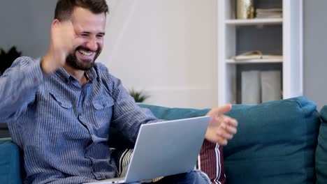 hombre emocionado por el éxito, trabajando en una computadora portátil