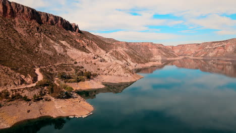 Bird's-eye-view-from-within-Canon-del-Atuel,-showcasing-its-mirror-like-waters-reflecting-the-sky-and-mountains