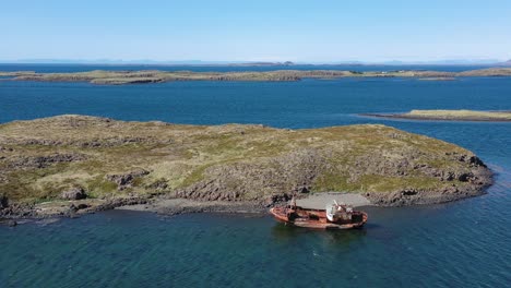 Antena-Sobre-Barco-Pesquero-Abandonado-Sentado-En-La-Orilla-De-Los-Fiordos-Del-Oeste-De-Islandia-1