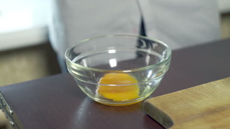 egg yolk falling in glass bowl. food ingredient preparing ingredients for baking