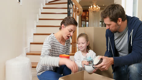 Family-unpacking-cardboard-boxes-in-there-new-home-4K-4k