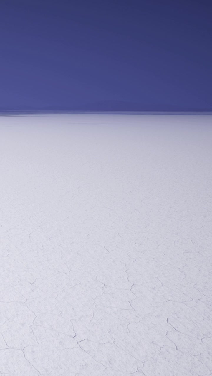 Expansive salt flat under a clear blue sky during the day