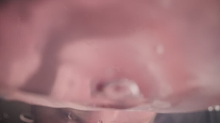 Una persona assetata beve una dolce bevanda rosa direttamente dalla bottiglia.