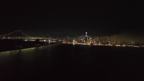 drone rising toward the downtown san francisco from the sea, misty night in usa