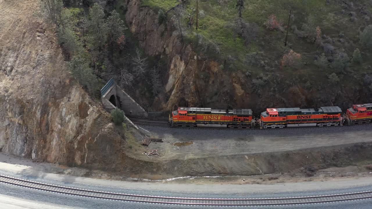 vuelo de avión no tripulado de cerca de un tren que va lanzó un túnel en el bucle teechapi en teechapi california