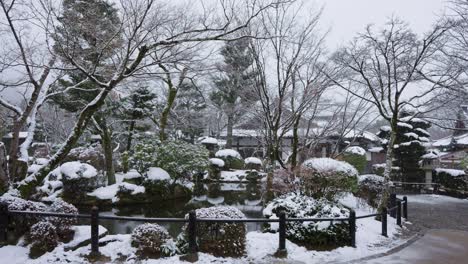 snow falling over japanese garden, winter in kyoto japan