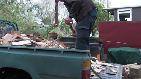 hombre maduro palear los recortes de madera para fuente de combustible de leña