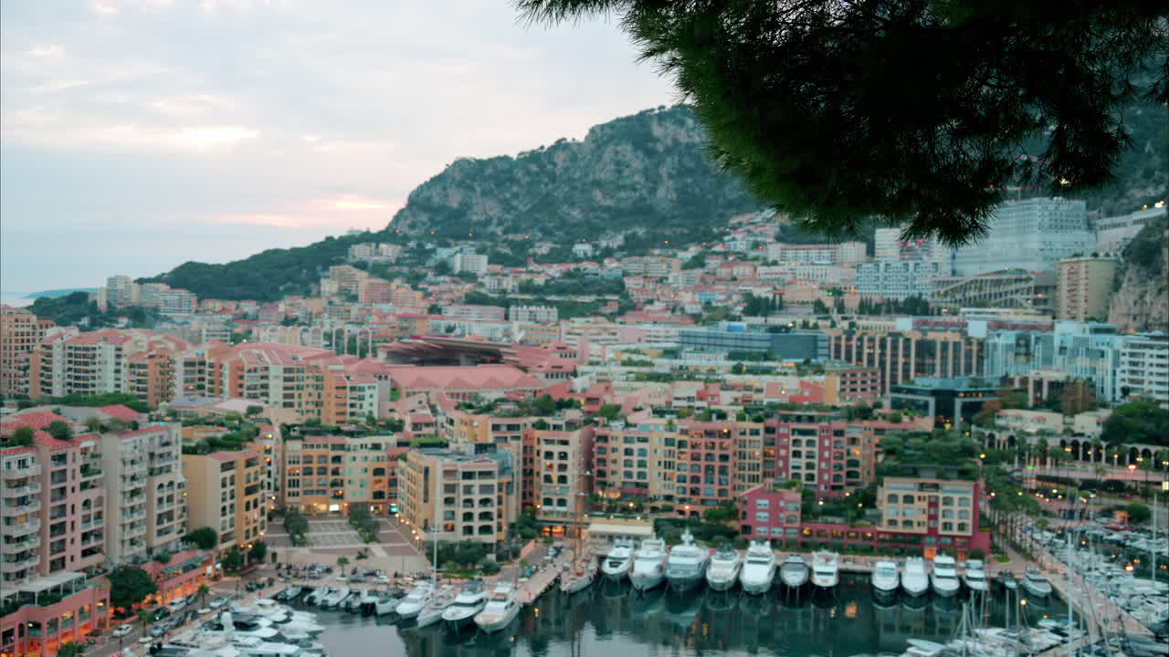 View of boats docked in the Port de Fontvieille with the skyline of Monaco on the background in the evening