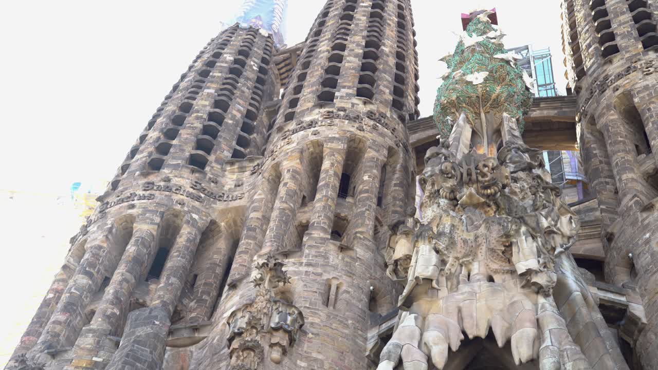 Handheld shot of the dove tree and turrets at the Nativity Facade entrance of La Sagrada Familia
