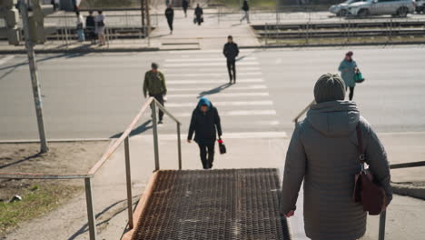 close view of people walking across a crosswalk on a sunny day, captured from an elevated perspective