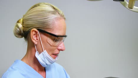 female dentist assisting male patient to wear virtual reality headset