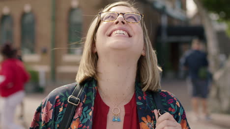 Retrato-De-Una-Mujer-De-Negocios-Rubia-De-Moda-Riendo-Optimista-Con-Gafas-Camisa-Floral-Disfrutando-De-Los-Viajes-Urbanos