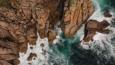aerial view of rugged coastal cliffs and crashing ocean waves