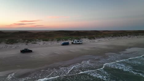 vehicle driving through the sandy shore of the beach in padre island,texas,usa - aerial drone shot