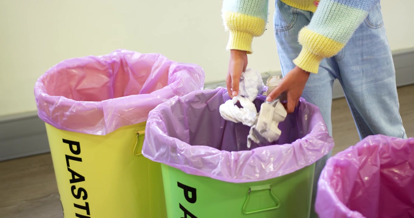 African American teen entering right holding crumpled paper, sorting into green bin, copy space