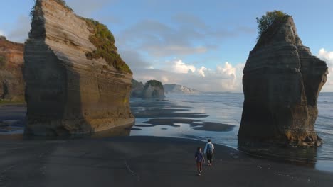 couple walking in the shore of the impressive three sisters beach