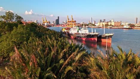 chao-phraya river with containers and cranes loading goods to container ship