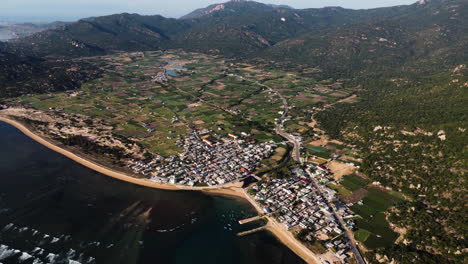 aerial seascape of fisherman village thai an vietnam travel destination famous for vineyard juicy grape wine production, drone fly above agricultural valley and hills in province of ninh thuan