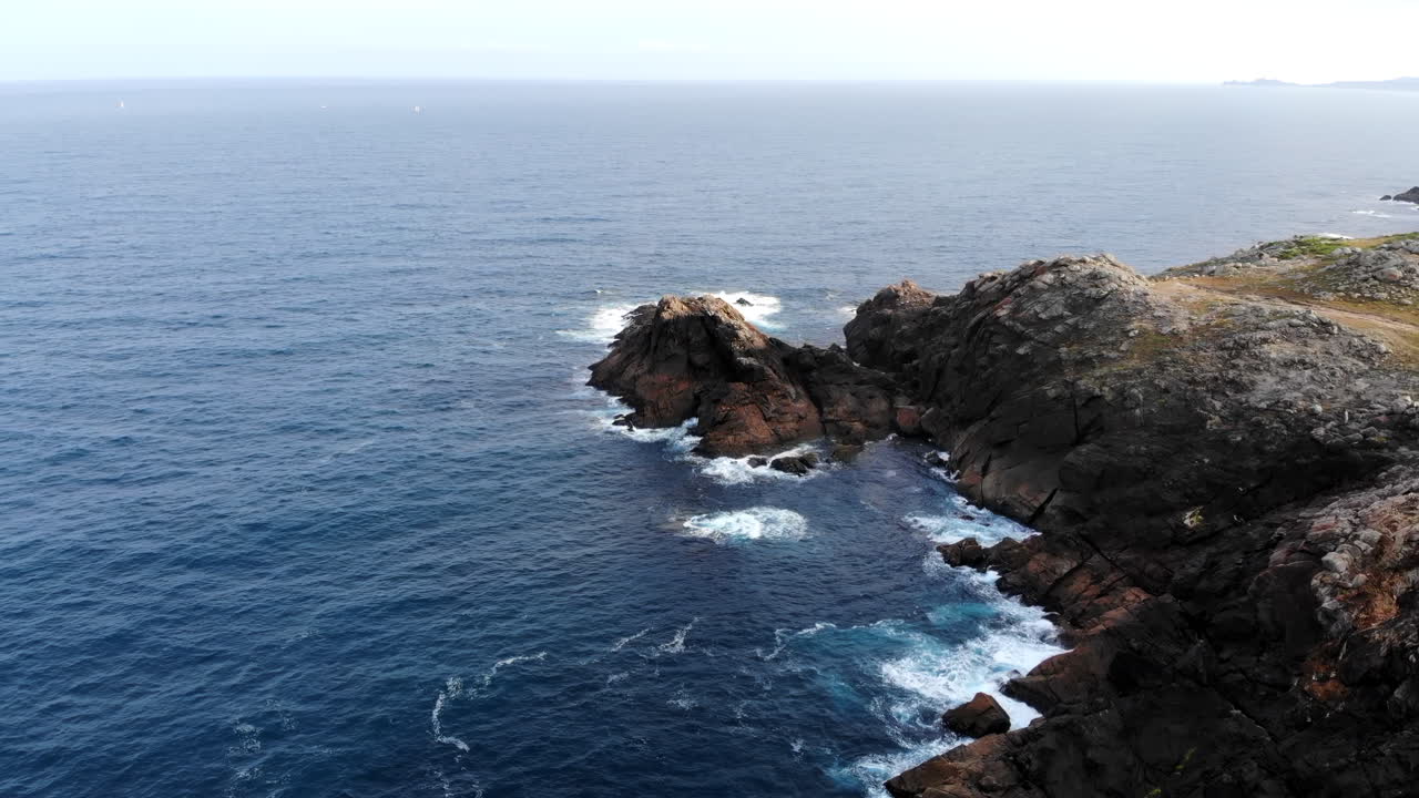 Veduta aerea di onde oceaniche che si infrangono contro una costa rocciosa frastagliata