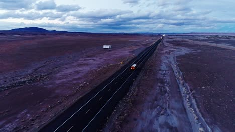 forward drone movement above evening road cutting through vast desert land, usa